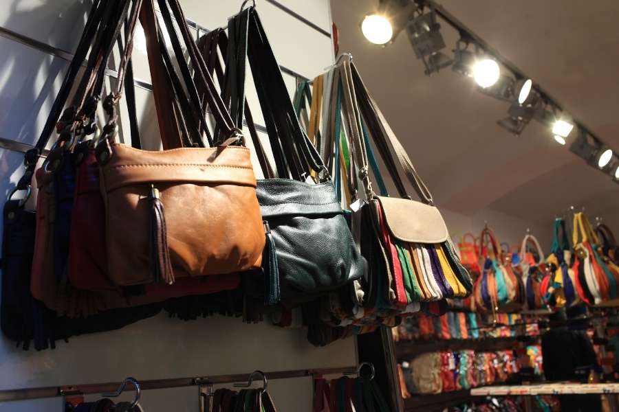 Designer handbags display in leather goods store with brown and black bags
