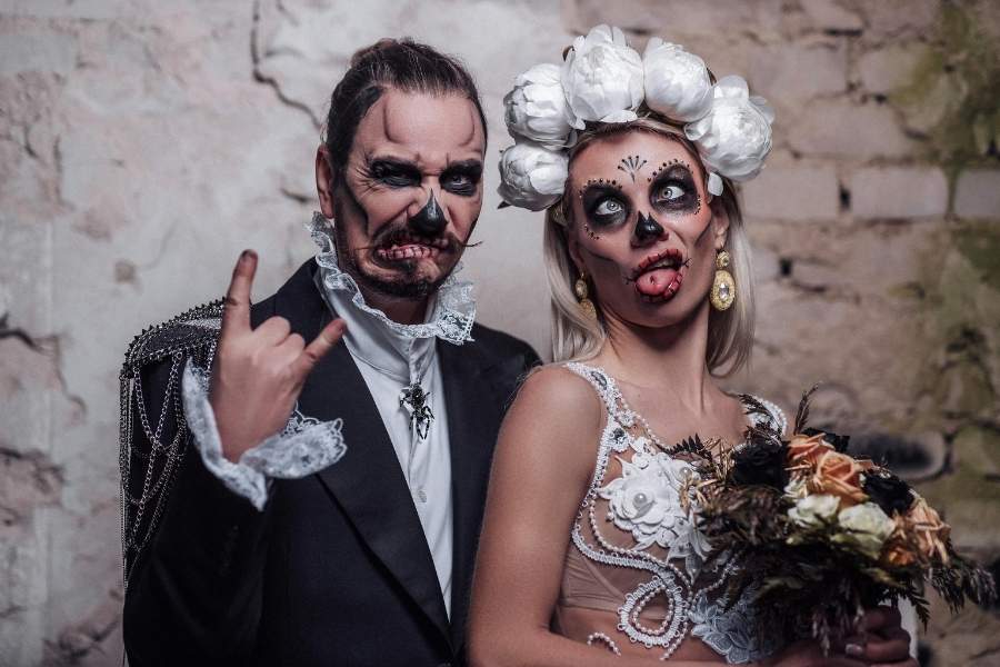 Couple wearing detailed Halloween makeup with skull and gothic designs