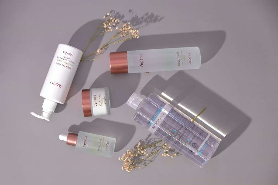 Skincare products arranged with flowers for an autumn equinox skincare routine.
