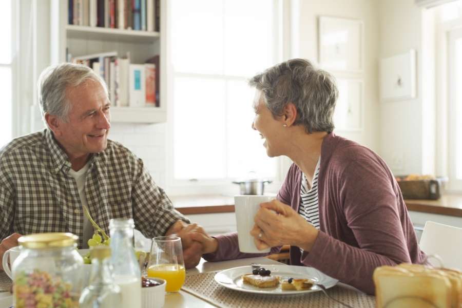 An older couple enjoying breakfast together while sharing motivation to start moving every day.