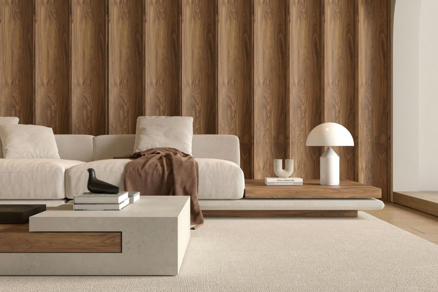 A modern minimalist living room featuring a stylish ceramic wall light placed on a wooden side table.